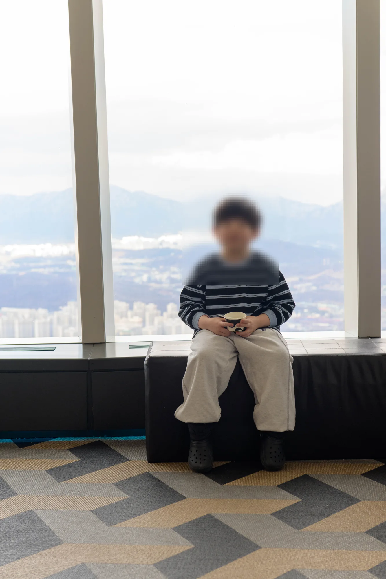 창가 벤치에 앉은 아들