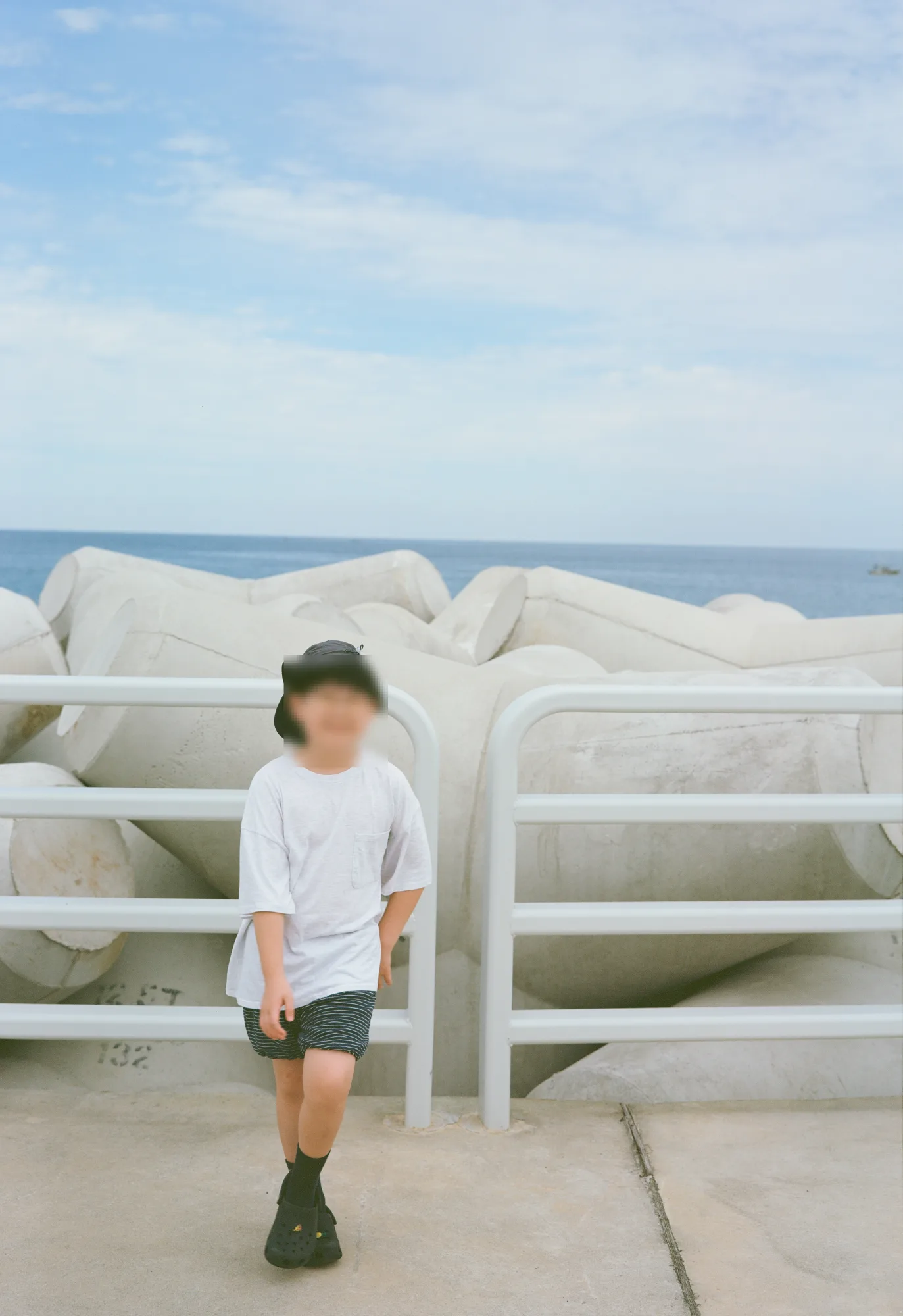 몸을 기울인 채 흐린 하늘 아래 선 모습