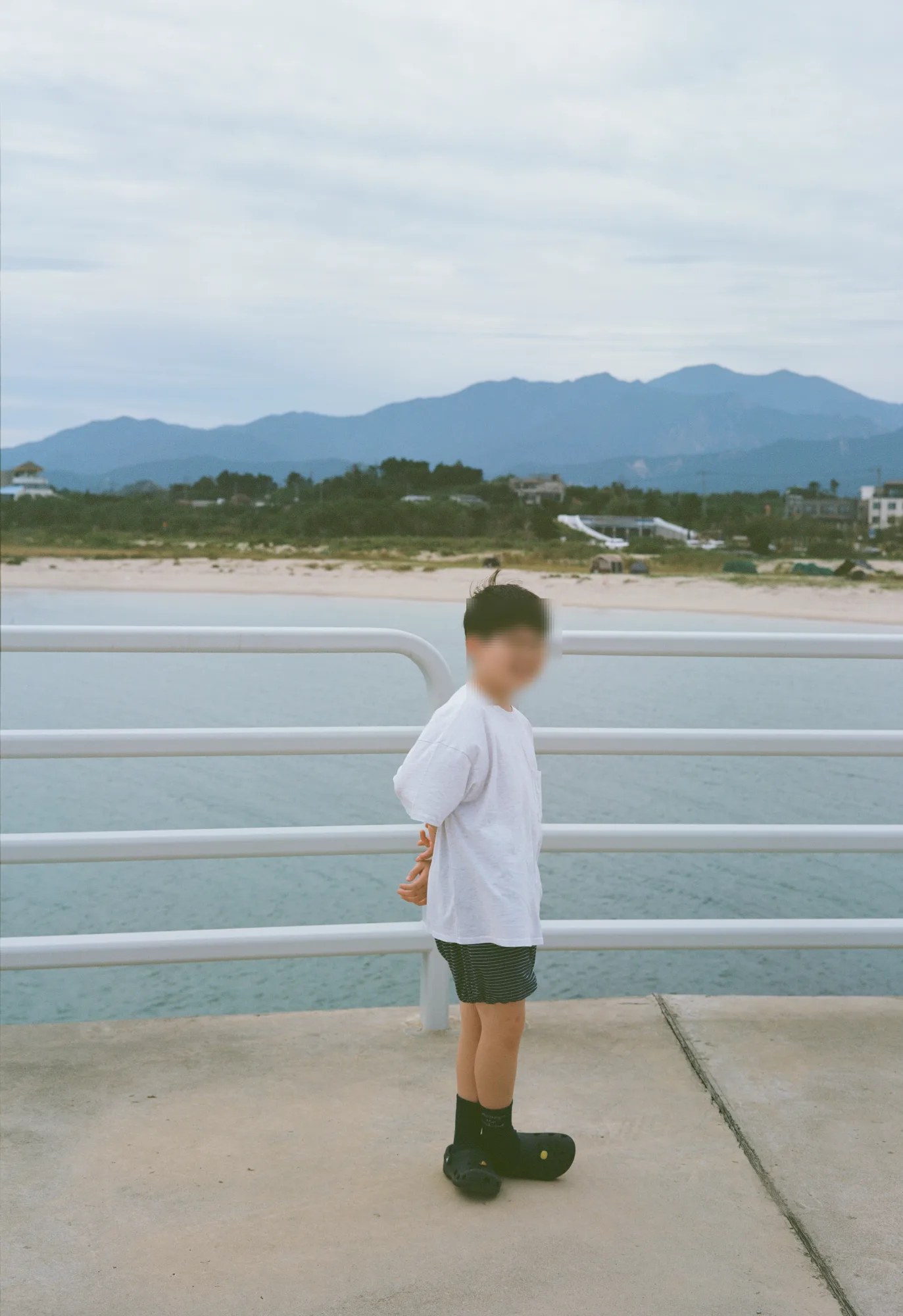 난간에 기대 먼 산을 바라보는 모습