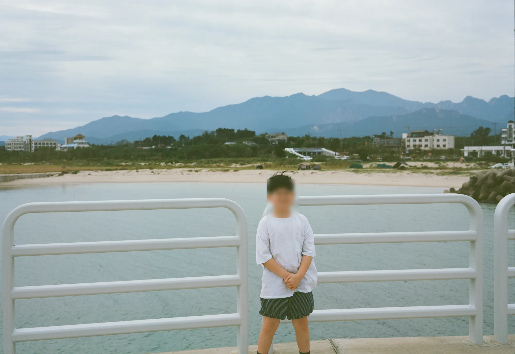 산줄기와 백사장을 배경으로 선 모습