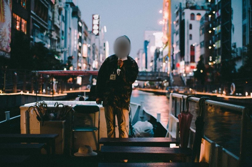 배 위에서 물건을 얼굴 앞에 든 사람, 얼굴은 흐림