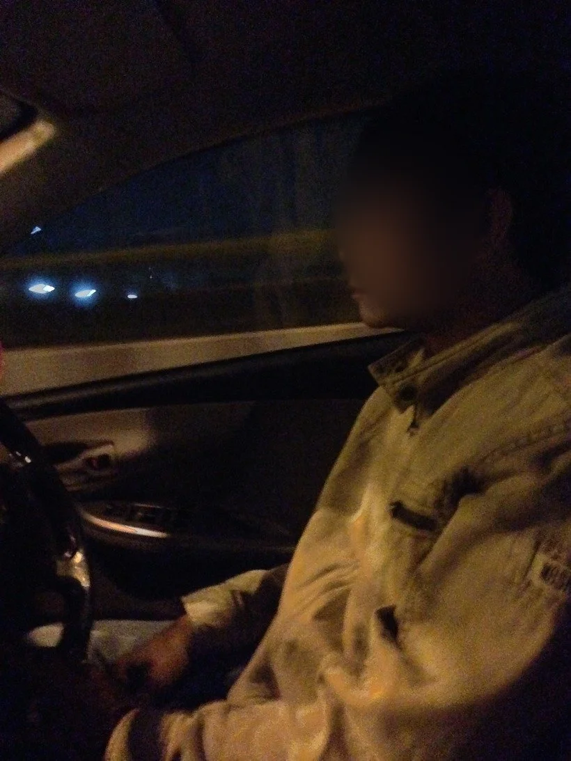 밤에 택시 운전석에 앉은 기사의 옆모습(얼굴 흐림 처리)